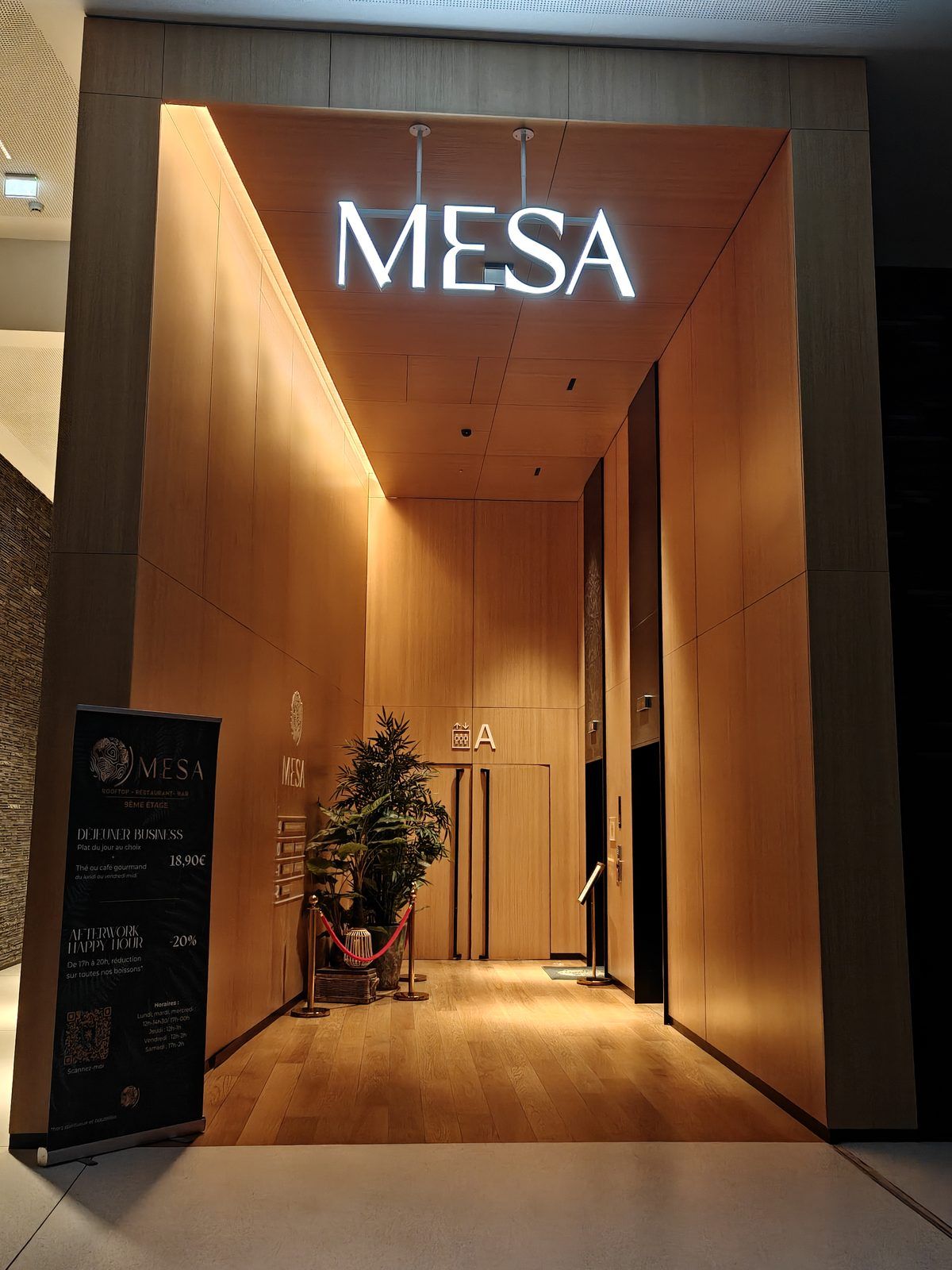 Hall d'entrée du Mesa Lille, enseigne lumineuse et ascenseurs vers le 9e étage